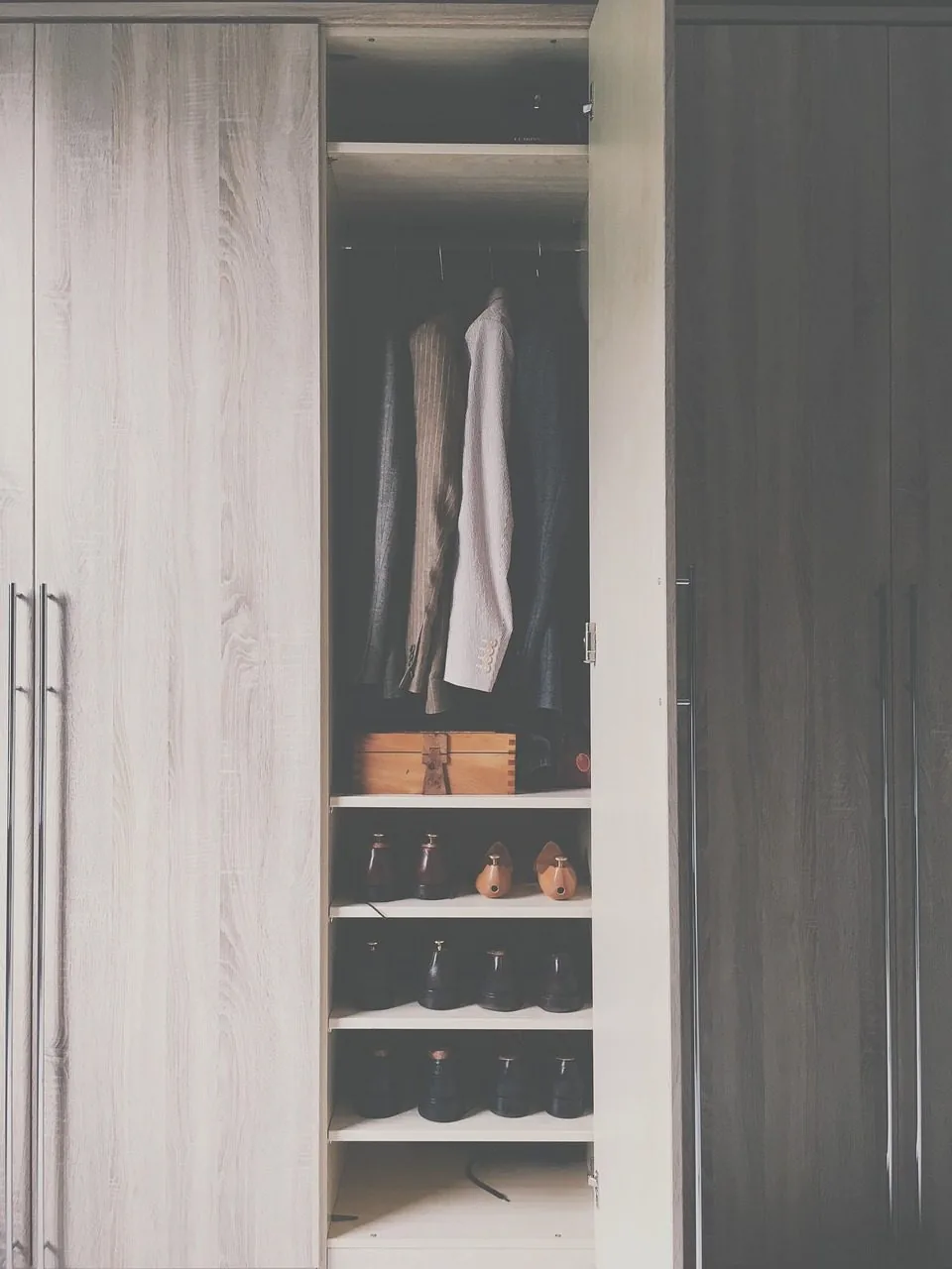 A closet shelf with fabric storage boxes in a row